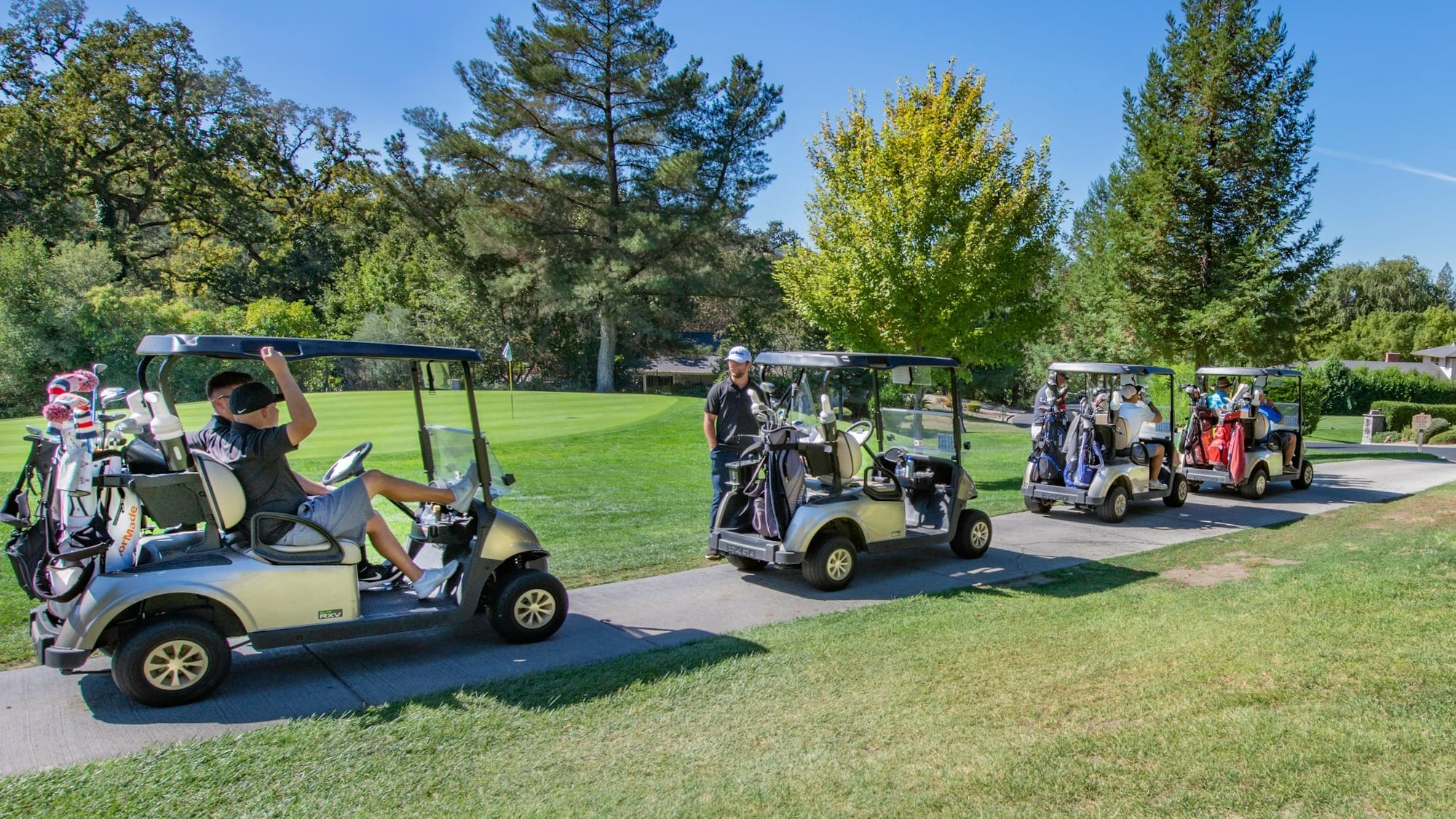 white golf cart on green grass field during daytime