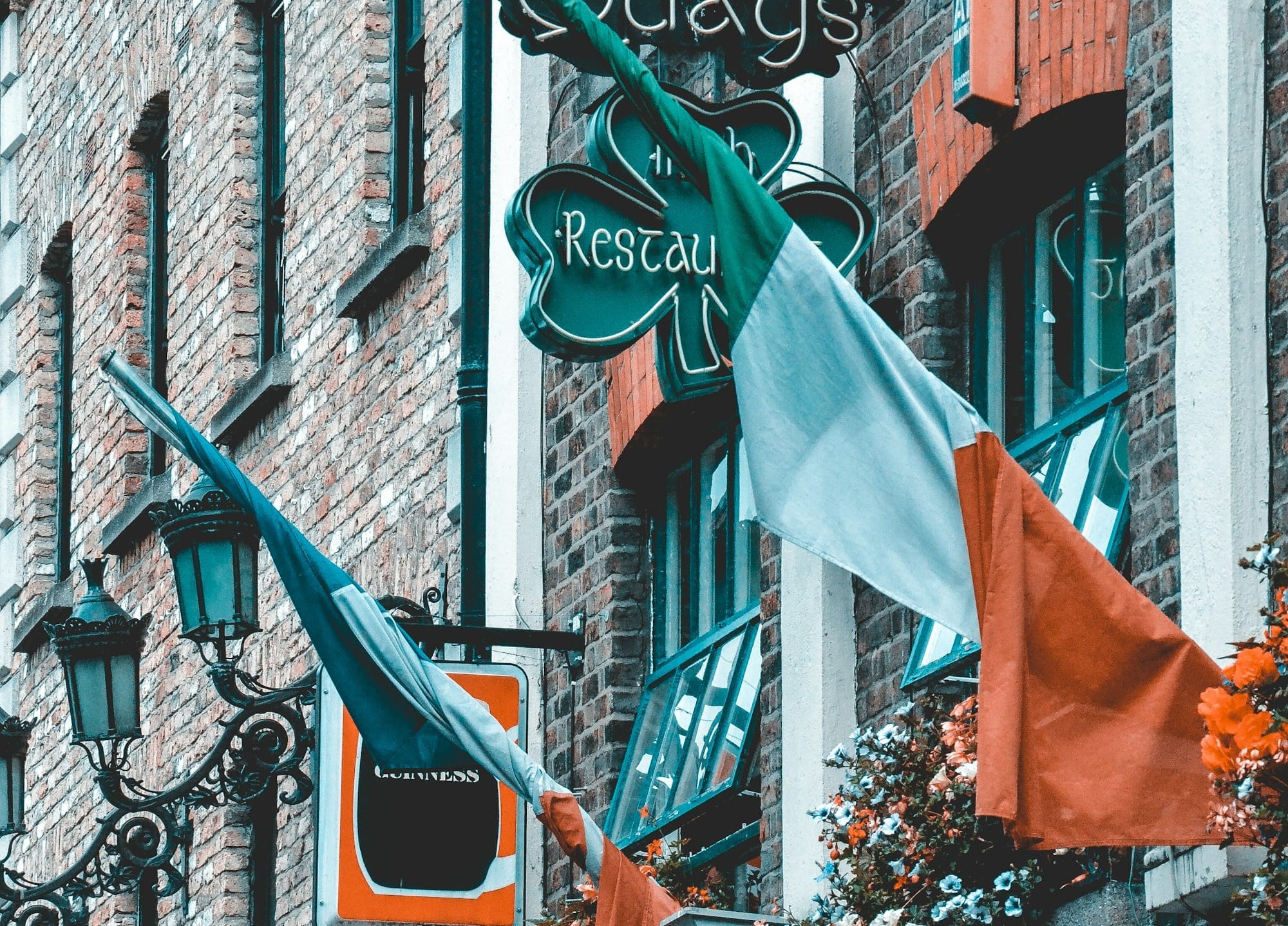 orange and green flags on black metal fence