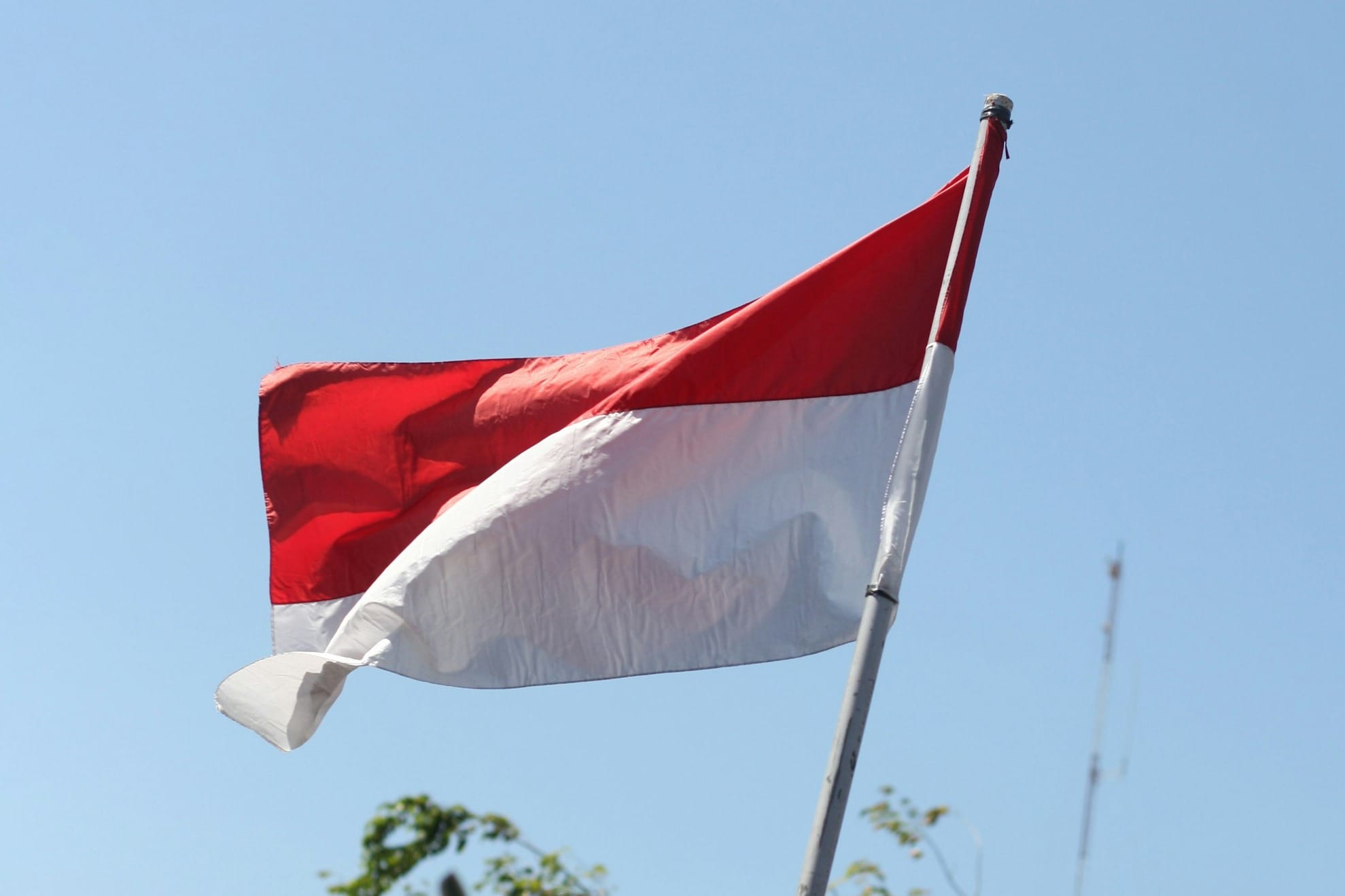 a red and white flag flying in the wind