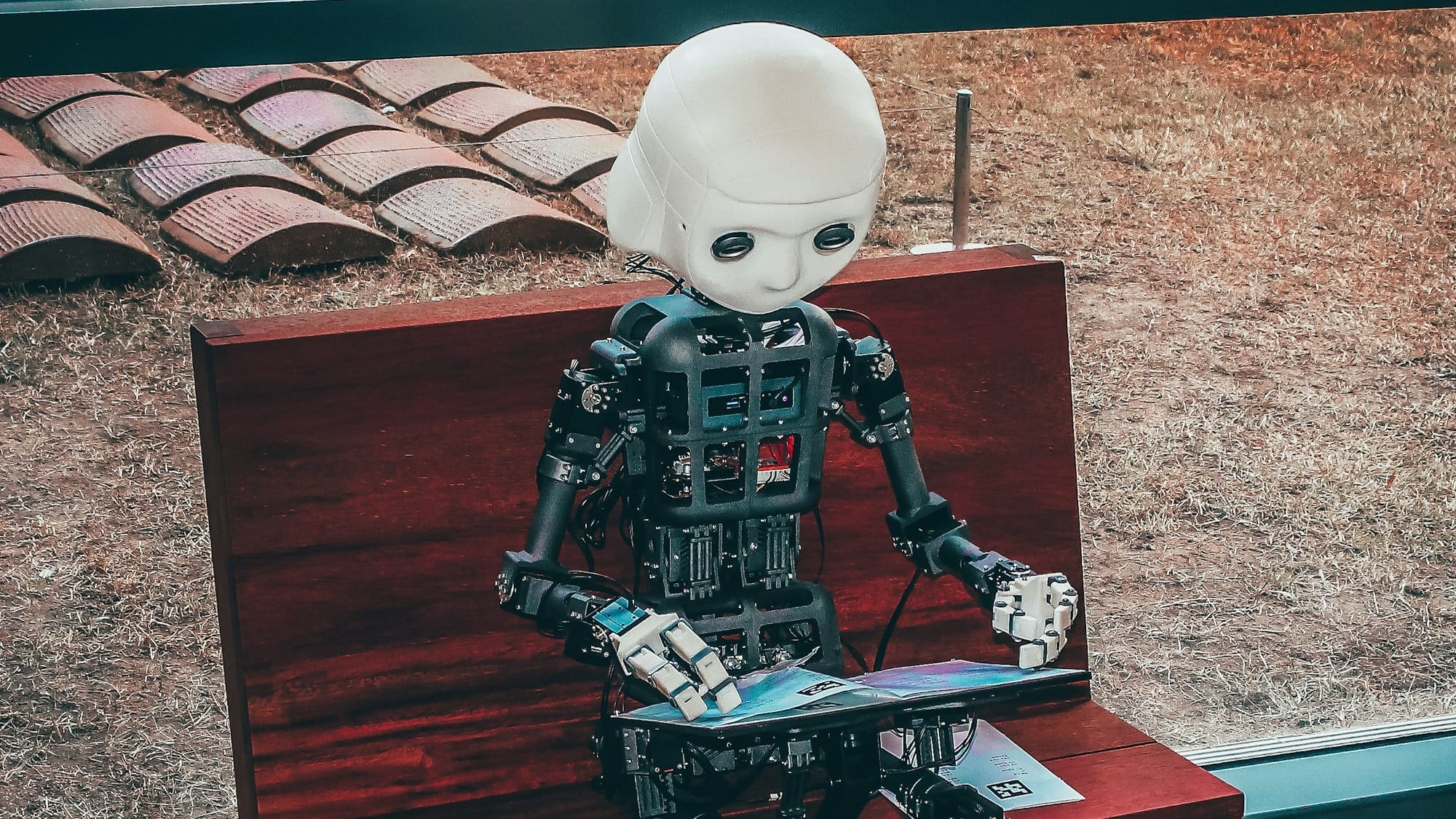 black and white robot toy on red wooden table