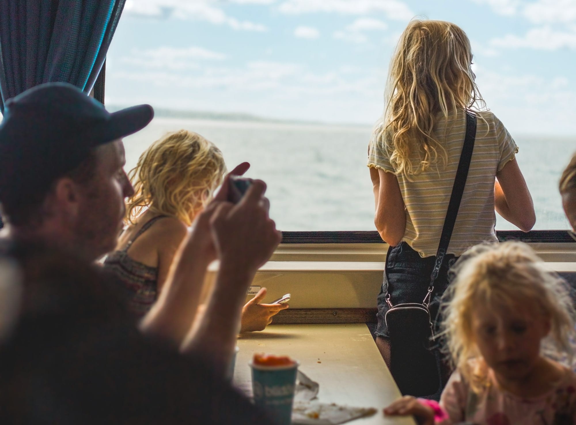 A group of people sitting at a table in front of a window