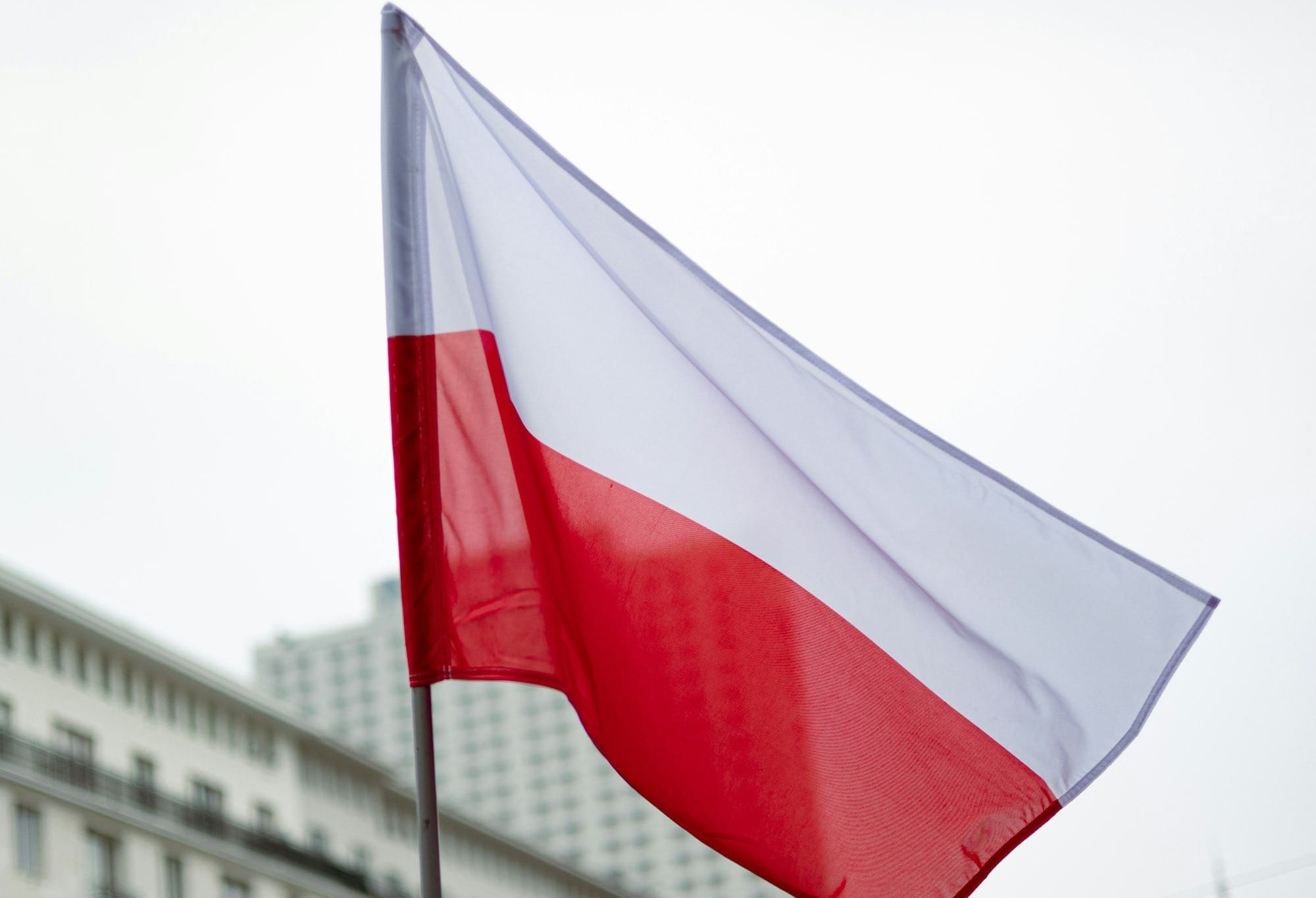 The polish flag waves in the breeze.
