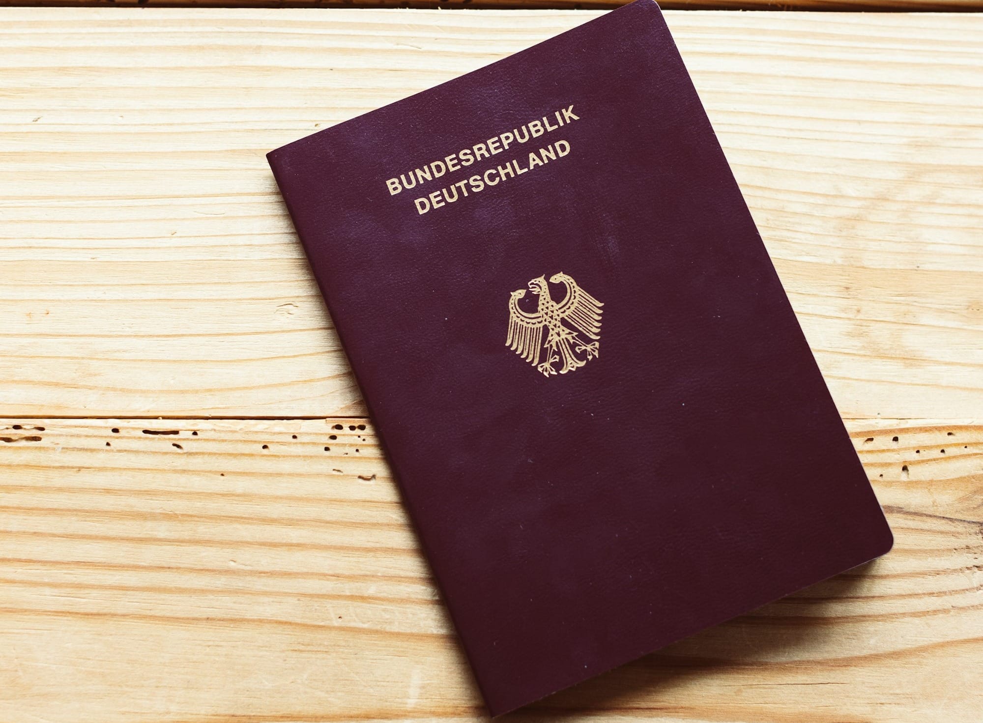 A purple passport sitting on top of a wooden table