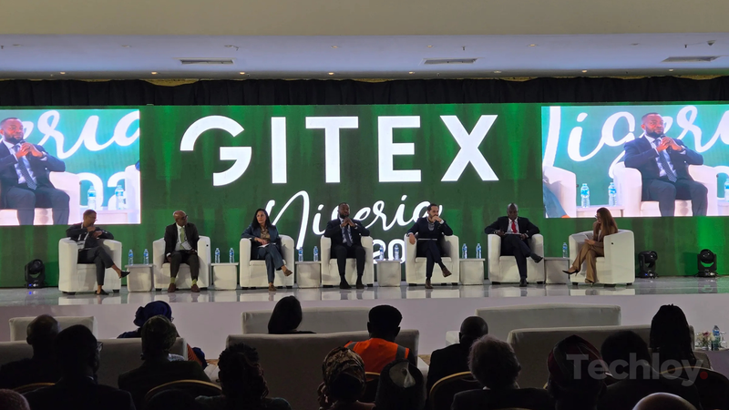A panel of seven industry leaders sits onstage in front of a large "GITEX Nigeria 2025" sign, speaking to an audience at the inaugural AI conference in Abuja, Nigeria on September 1, 2025.